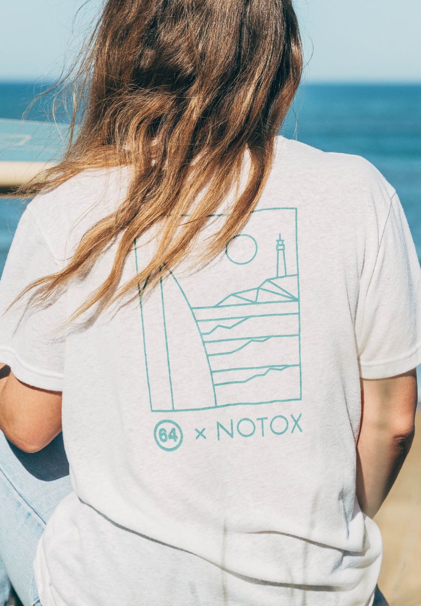 Femme face à l'océan portant le t shirt écru Notox x 64