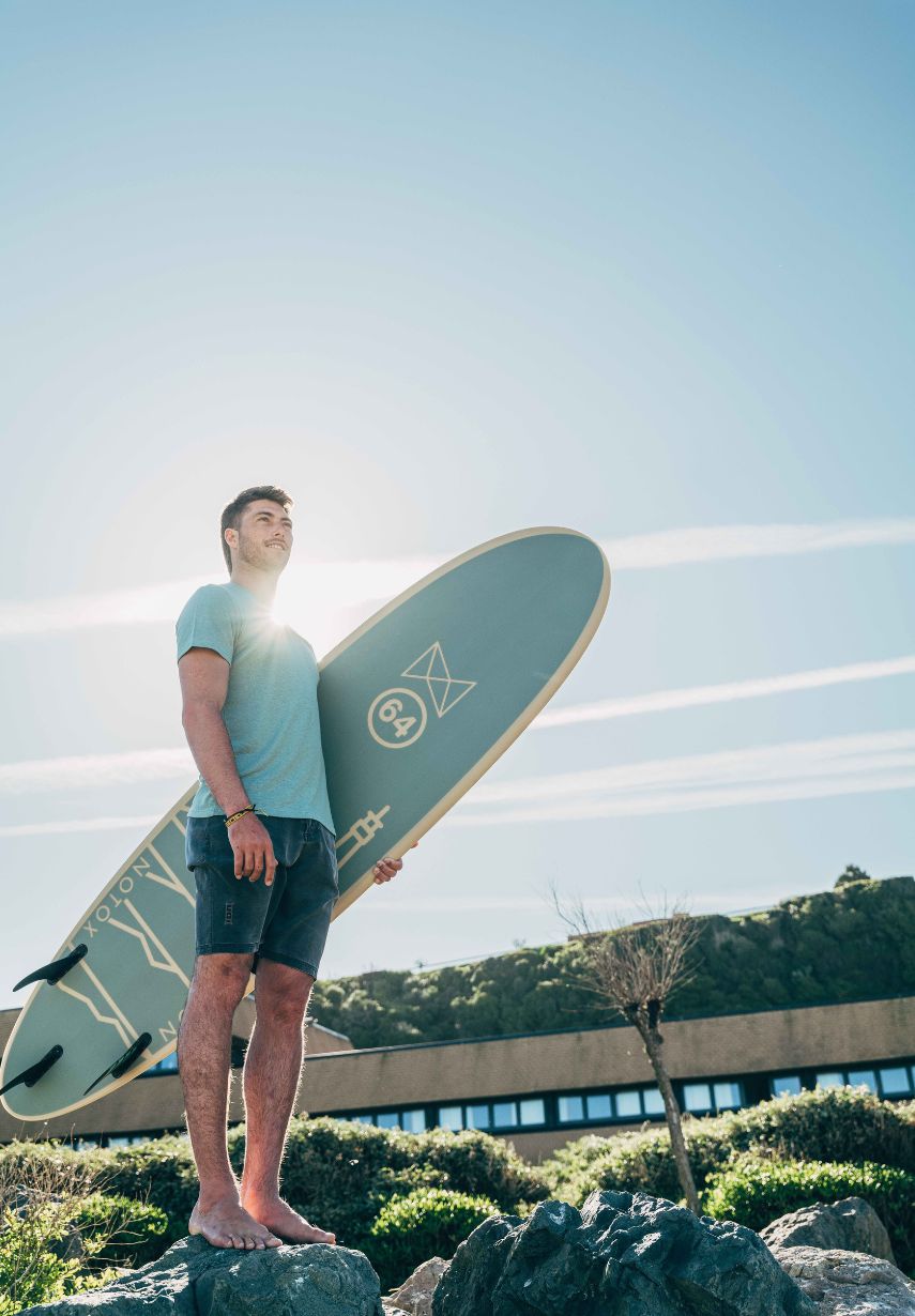 Homme tenant la planche de surf NOTOX x 64 